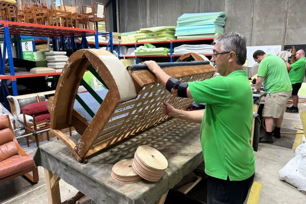 A team member of Covesmore Solutions reupholstering a couch in the Sydney workshop at Blacktown